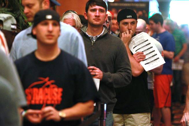Bettors stand in line to make their wagers at the LVH sports book during the second round of the NCAA basketball tournament Thursday, March 20, 2014.