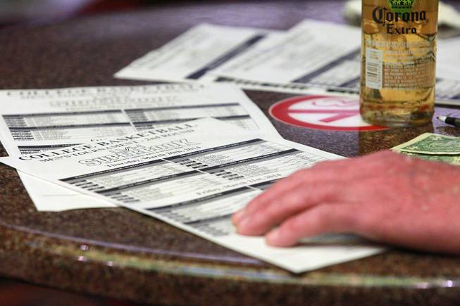 A bettor and his odds sheets at the LVH sports book during the second round of the NCAA basketball tournament Thursday, March 20, 2014.