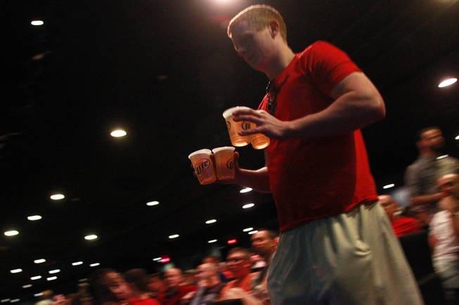 A patron carries beer back to his seat in the theater of the LVH during the second round of the NCAA basketball tournament Thursday, March 20, 2014.