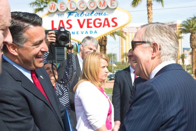 Nevada Governer Brian Sandoval greets U.S. Senate Majority Leader Harry Reid before meeting with the press to discuss clean energy investment in Nevada Thursday, March 20, 2014.