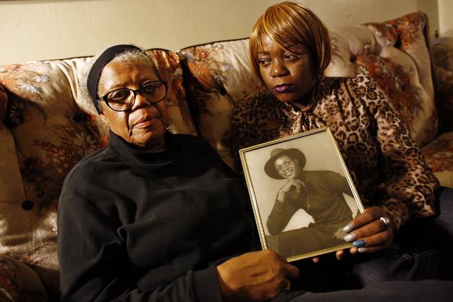 In this March 12, 2014, photo, Alma Murdough and her daughter Cheryl Warner hold a photo of Murdough's son at her home in the Queens borough of New York. Jerome Murdough, a mentally ill, homeless former Marine arrested for sleeping in the roof landing of a New York City public housing project died last month in a Rikers Island jail cell that multiple city officials say was at least 100 degrees when his body was discovered.