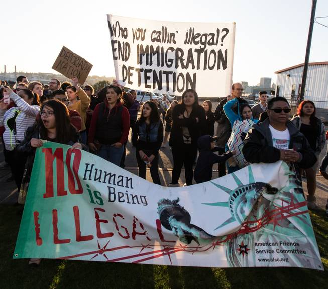 Demonstrators hold signs opposing deportations, during a rally outside the Northwest Detention Center in Tacoma, Wash., Tuesday, March 11, 2014. 