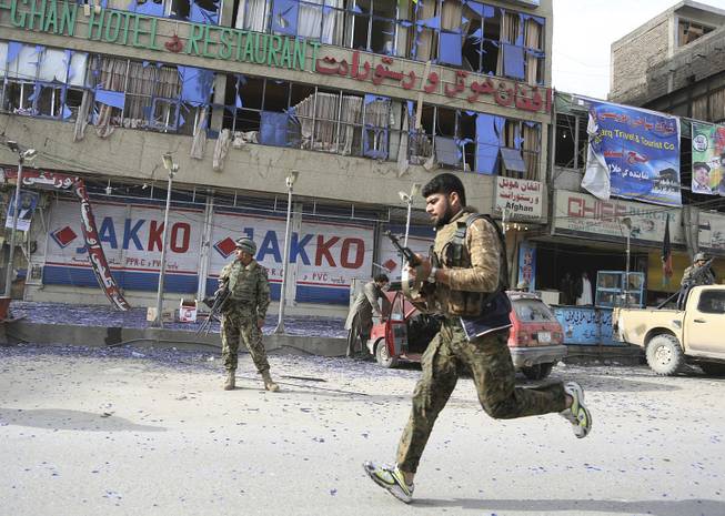 Afghan police officers arrive to the scene after a multi-pronged attack on a police station in Jalalabad, the capital of eastern Nangarhar province, Afghanistan, Thursday, March 20, 2014. 