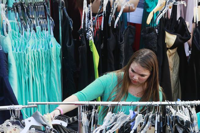Sydney Martin from Basic High looks through a rack of dresses during Las Vegas Prom Closet's "Operation Glass Slipper" Saturday, March 22, 2014.