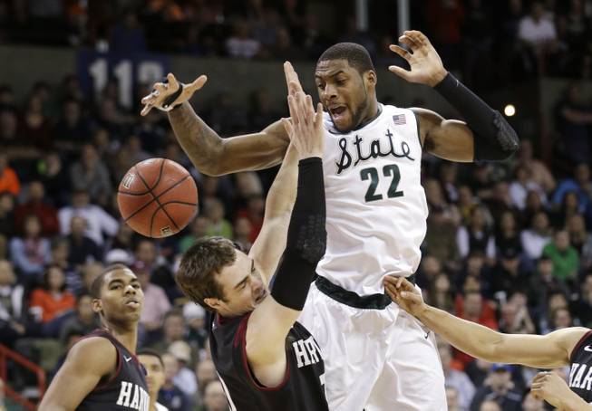 Michigan State's Branden Dawson (22) and Harvard's Laurent Rivard go for a loose ball in the second half during the third round of the NCAA men's college basketball tournament in Spokane, Wash., Saturday, March 22, 2014. Michigan State won 80-73.