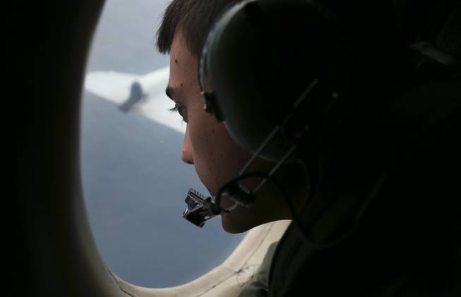 Sgt. Matthew Falanga, onboard a Royal Australian Air Force AP-3C Orion, searches for the missing Malaysia Airlines Flight 370 in the southern Indian Ocean off Australia on Saturday, March 22, 2014.
