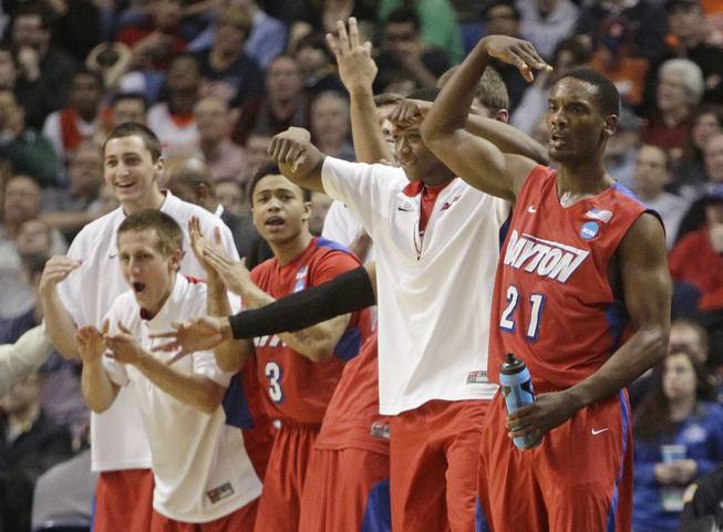 Dayton's Dyshawn Pierre (21) celebrates with teammates during the second half of a third-round game against Syracuse in the NCAA men's college basketball tournament Saturday, March 22, 2014, in Buffalo, N.Y.
