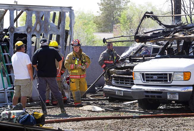 Clark Country Firefighters mop up after a backyard blaze that started in a recreational vehicle near East Windmill Avenue and Bermuda Road Sunday, March 23, 2014. Two RV's, a shed and a trailer were destroyed but there were no injuries reported in the fire.