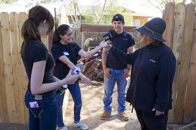 Sharon Ousley-Linsenbardt , right, talks to volunteers after they finished a painting project at The Farm, 7222 West Grand Teton Drive, Sunday, March 23, 2014. From left, Aleigh Blake, Rachel Finley and Justin Tanner. STEVE MARCUS