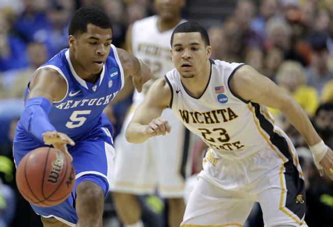 Kentucky guard Andrew Harrison (5) and Wichita State guard Fred VanVleet (23) go for a loose ball during the first half of a third-round game of the NCAA college basketball tournament Sunday, March 23, 2014, in St. Louis.