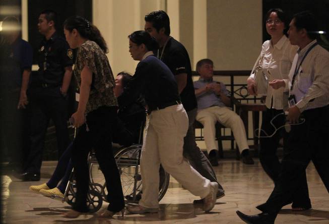 A Chinese relative of passengers aboard a missing Malaysia Airlines plane, is pushed on a wheel chair at a hotel in Bangi, outside Kuala Lumpur, Malaysia, Monday, March 24, 2014.