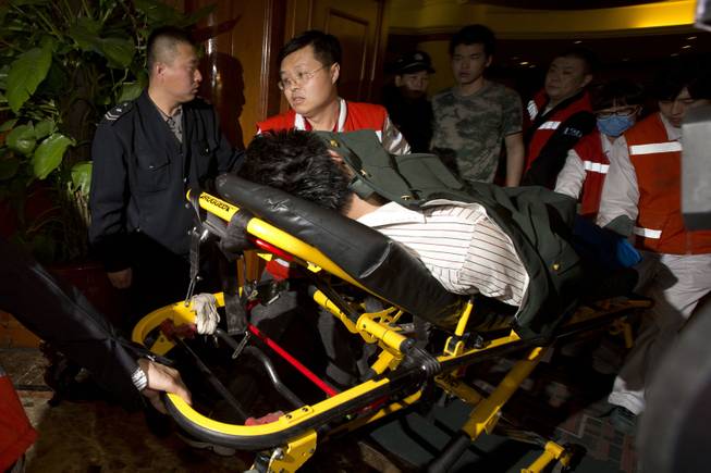 A relative of one of the Chinese passengers aboard the Malaysia Airlines, MH370 is taken away on a stretcher after being told of the latest news in Beijing, China, Monday, March 24, 2014. 