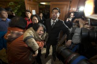 A relative of one of the Chinese passengers aboard the Malaysia Airlines, MH370 collapses in grief after being told of the latest news in Beijing, China, Monday, March 24, 2014. 