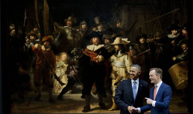 U.S. President Barack Obama, left, and museum director Wim Pijbes pose in front of  Dutch master Rembrandt's The Night Watch painting during a visit to the Rijksmuseum in Amsterdam, Netherlands, Monday, March 24, 2014. 