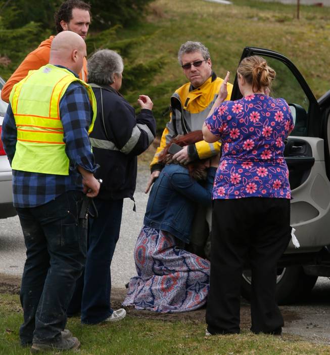 A woman collapses near the Oso Fire Department as neighbors look for news regarding the fatal mudslide that washed over homes and over Highway 530 east of Oso, Wash., Saturday, March 22, 2014. Highway 530 was closed in both directions, and authorities confirmed at least 2 fatalities by Saturday afternoon.