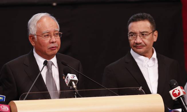 Malaysian Prime Minister Najib Razak, left, and acting transport minister Hishammuddin Hussein speak during the press conference about the missing Malaysia Airlines jet, MH370, at Putra World Trade Centre in Kuala Lumpur, Malaysia, Monday, March 24, 2014. Razak said a new analysis of satellite data indicates the missing plane plunged into a remote corner of the Indian Ocean.