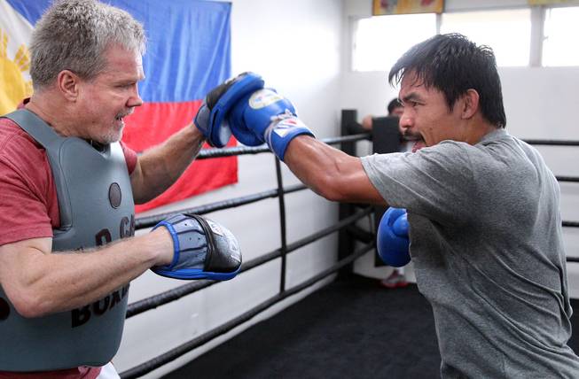 Manny Pacquiao hits the mitts with Hall of Fame trainer Freddie Roach, left, during training Monday, March 24, 2014, for his eagerly-anticipated rematch against undefeated WBO World Welterweight champion Timothy Bradley.