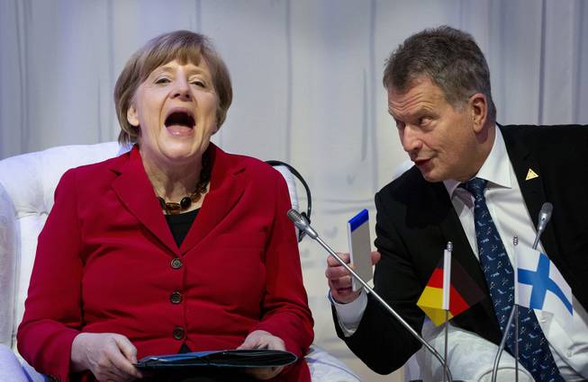 German Chancellor Angela Merkel, laughs talking to Finland's President Sauli Niinisto, right, as they attend an informal plenary session on the last day of the Nuclear Security Summit (NSS) in The Hague, Netherlands, Tuesday, March 25, 2014. 
