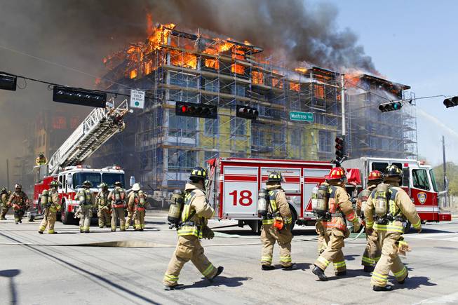 Houston firefighters work to extinguish a five-alarm fire at a construction site Tuesday, March 25, 2014, in Houston. Fire officials said more than 200 emergency personnel were at the scene Tuesday afternoon and were working to protect nearby buildings. 