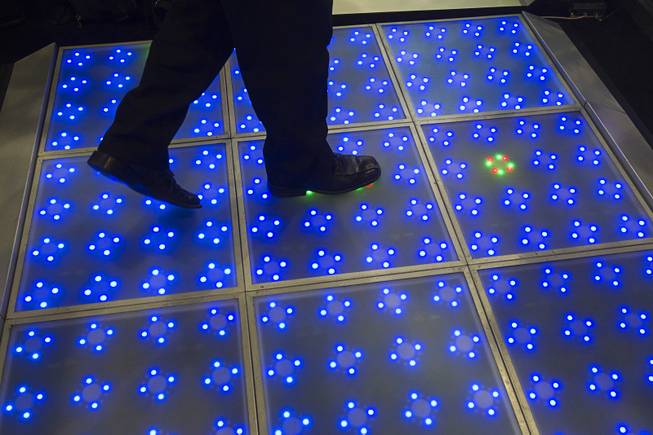 Ozzie Sanchez of Pro Sound and Designs Las Vegas walks over an LED dance floor during the Nightclub & Bar Convention and Trade Show at the Las Vegas Convention Center Wednesday March 26, 2014.