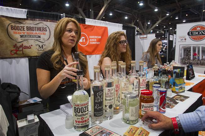 Melanie Andrade, left, of Booze Brothers Beverage, shows off local products during the Nightclub & Bar Convention and Trade Show at the Las Vegas Convention Center Wednesday March 26, 2014.