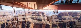 In this Tuesday, March, 25, 2014, photo provided by Abseilon USA via AZ Photos, technicians dangle from a series of ropes before polishing the underside glass at Grand Canyon Skywalk in Hualapai Reservation, Ariz. The more than 40 panes of glass underneath the horseshoe-shaped bridge on the Hualapai reservation aren’t easily accessible. The structure juts out 70 feet from the edge of the Grand Canyon, offering visitors a view of the Colorado River 4,000 feet below.