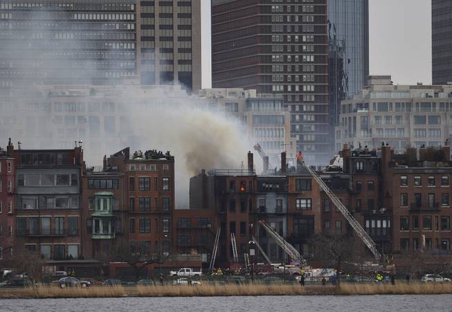 A multi-alarm blaze at a structure is seen from Cambridge, Mass., as firefighters respond, Wednesday, March 26, 2014. A Boston city councilor said two firefighters have died in a fire that ripped through a brownstone. 