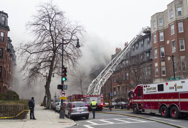 Firefighters fight a multi-alarm fire at a four-story brownstone in the Back Bay neighborhood near the Charles River, Wednesday, March 26, 2014, in Boston. Boston EMS spokesman Nick Martin says four people, including at least three firefighters, have been taken to hospitals.