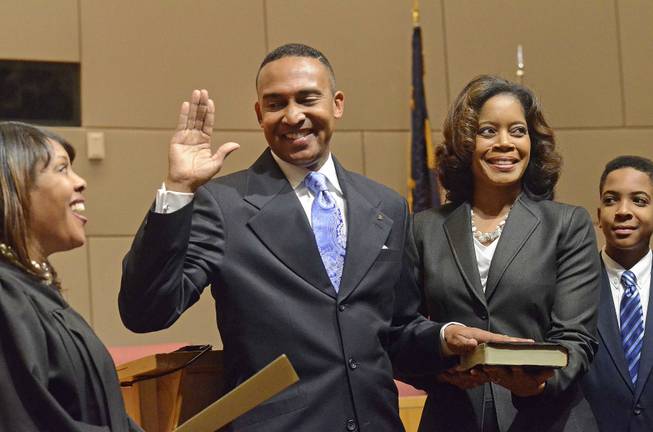 Mecklenburg County District Judge Tyyawdi Hands, left, administers the oath of office to Patrick Cannon as Charlotte's new mayor, with his wife, Trenna, and son Patrick, next to him, at the Charlotte Government Center, in Charlotte, N.C., Dec. 2, 2013.