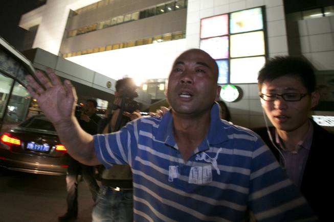 A relative of one of the Chinese passengers aboard the Malaysia Airlines jet, MH370, runs out of the hotel in tears after being told of the latest news in Beijing, China, Monday, March 24, 2014, that satellite data indicates the missing plane crashed into a remote corner of the Indian Ocean.