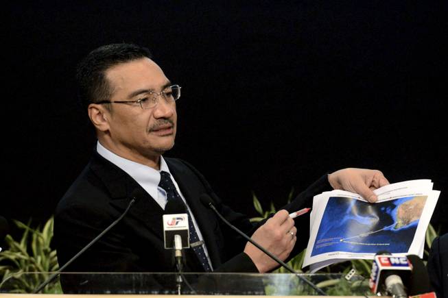 Malaysia's Defense Minister and acting Transport Minister Hishammuddin Hussein shows a printout of the latest satellite image of objects that might be from the missing Malaysia Airlines plane, at Putra World Trade Center in Kuala Lumpur, Malaysia, Wednesday, March 26, 2014. Hishammuddin said the objects were seen close to where three other satellites previously detected objects.
