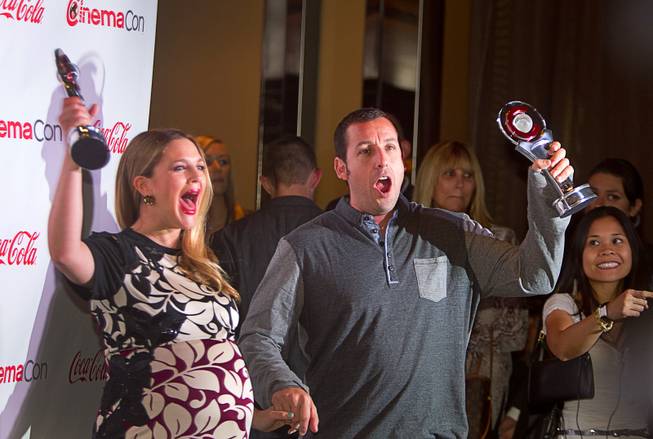 Drew Barrymore and Adam Sandler hold up awards as they arrive for the Big Screen Achievement Awards during CinemaCon, the official convention of the National Association of Theatre Owners, at Caesars Palace Thursday, March 27, 2014. Barrymore was the recipient of the Female Star of the Year award. Sandler received the Male Star of the Year award.