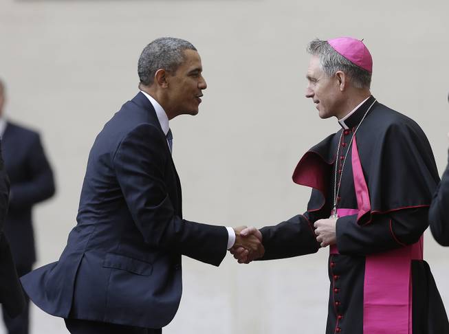 President Barack Obama, left, is welcomed by Archbishop George Gaenswein, prefect of the papal household, as he arrives at the Vatican to meet Pope Francis, Thursday, March 27, 2014. 