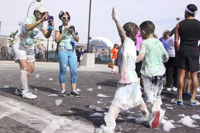 Sabrina Dixon, left, and Samantha Jermee, right, take a photo of Kane and Drayden after finishing the 5k Bubble Run in downtown Las Vegas Saturday, March 29, 2014.