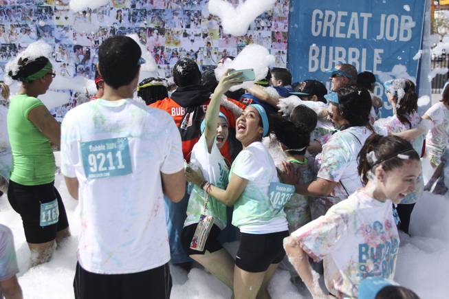 Participants give a newly wed couple a group hug during the 5k Bubble Run in downtown Las Vegas Saturday, March 29, 2014.
