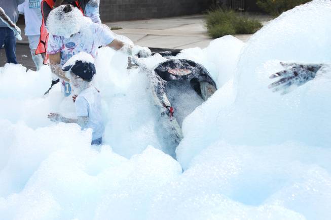 Participants push through the blue foam bog station during the 5k Bubble Run in downtown Las Vegas Saturday, March 29, 2014.