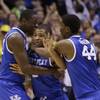 Kentucky's Aaron Harrison, center, is congratulated by teammates Julius Randle, left, and Dakari Johnson after making a 3-point basket in the final seconds of the second half of the NCAA Midwest Regional final game against Michigan on Sunday, March 30, 2014, in Indianapolis. Kentucky won 75-72 to advance to the Final Four.