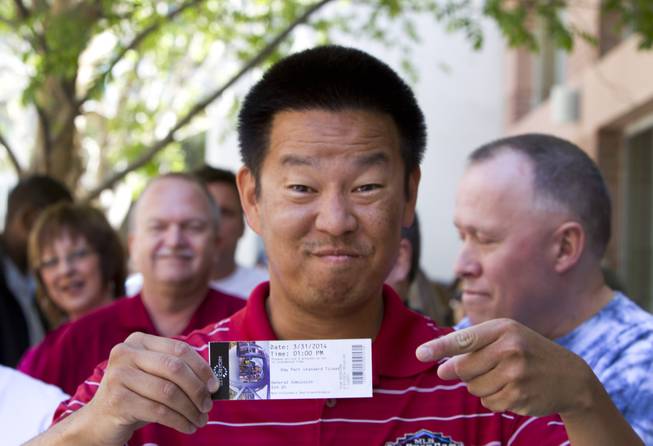 Van Kim of Phoenix shows off his ticket before the first public ride on the 550-foot-tall High Roller observation wheel Monday, March 31, 2014. Kim says his ticket was the first sold to the public. The observation wheel, the tallest in the world, is part of the Linq project, a $550 million development by Caesars Entertainment Corp.