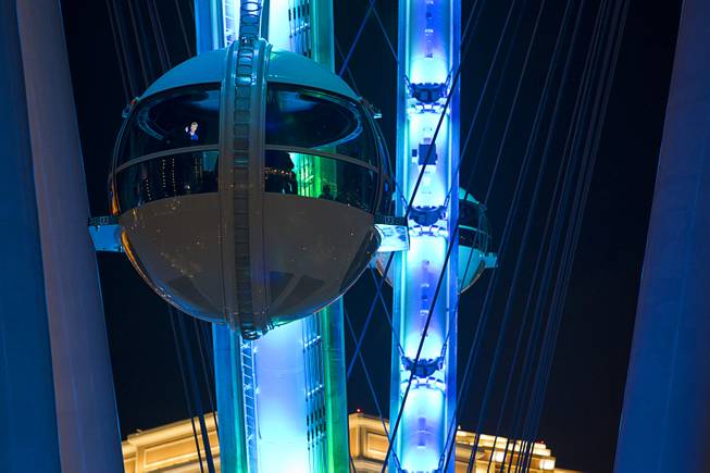People ride in cabins of the 550-foot-tall High Roller observation wheel Monday, March 31, 2014. The observation wheel, the tallest in the world, is part of the Linq project, a $550 million development by Caesars Entertainment Corp. The ride is now open to the public.