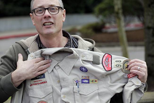 Geoff McGrath holds his Boy Scout scoutmaster uniform shirt for the Seattle troop he led, Tuesday, April 1, 2014, in Bellevue, Wash. 