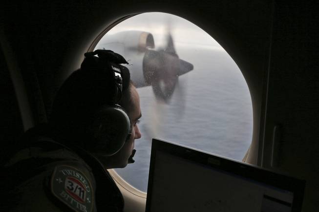  In this Saturday, March 22, 2014, file photo, Flight officer Rayan Gharazeddine on board a Royal Australian Air Force AP-3C Orion, searches for the missing Malaysia Airlines Flight MH370 in southern Indian Ocean.