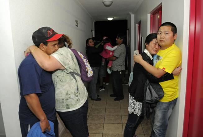 People embrace on the upper floor of an apartment building located a few blocks from the coast where they gathered to avoid a possible tsunami after an earthquake in Iquique, Chile, Tuesday, April 1, 2014. A powerful magnitude-8.2 earthquake struck off Chile's northern coast Tuesday night. There were no immediate reports of injuries or major damage, but buildings shook in nearby Peru and in Bolivia's high altitude capital of La Paz. (AP Photo/Cristian Viveros) NO PUBLICAR EN CHILE