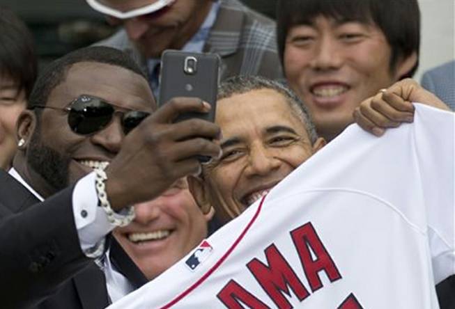 Boston Red Sox designated hitter David "Big Papi" Ortiz takes a selfie with President Barack Obama, holding a Boston Red Sox jersey presented to him, during a ceremony Tuesday, April 1, 2014, on the South Lawn of the White House in Washington, where the president honored the 2013 World Series baseball champion Red Sox.