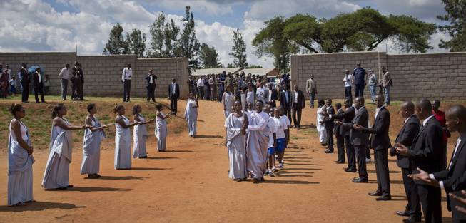 Torch-bearers carry a small flame of remembrance to a ceremony where hundreds gathered to hear genocide memories, at the Petit Seminaire school in Ndera, east of the capital Kigali, in Rwanda Thursday, April 3, 2014.