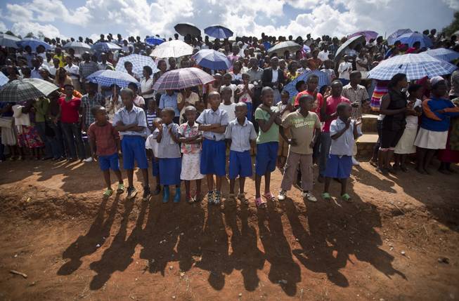 Rwandan children wait for a torch ceremony where hundreds gathered for the arrival of a small flame of remembrance and to hear genocide memories, at the Petit Seminaire school in Ndera, east of the capital Kigali, in Rwanda Thursday, April 3, 2014.