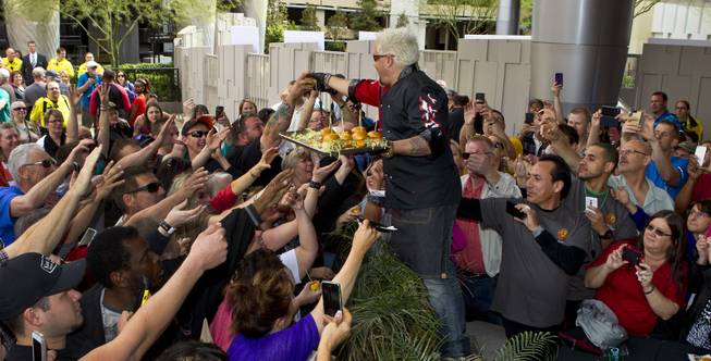 Guy Fieri serves burgers to fans outside his first Las Vegas restaurant, Guy Fieri's Vegas Kitchen & Bar on Friday, April 4, 2014.