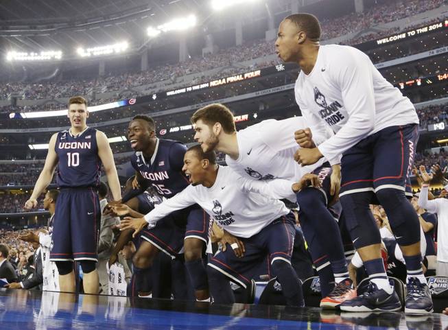 Connecticut players celebrate against Florida in the final moments of the NCAA Final Four game Saturday, April 5, 2014, in Arlington, Texas. Connecticut won 63-53.