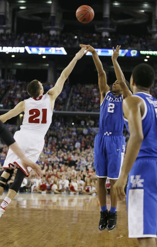 Kentucky guard Aaron Harrison makes a 3-point basket in the final seconds over Wisconsin guard Josh Gasser to win the game 74-73 on Saturday, April 5, 2014, in Arlington, Texas. 