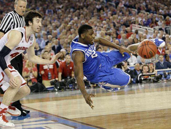 Kentucky forward Alex Poythress (22) saves the ball from going out as Wisconsin forward Frank Kaminsky (44) defends during the second half of an NCAA Final Four game Saturday, April 5, 2014, in Arlington, Texas. 