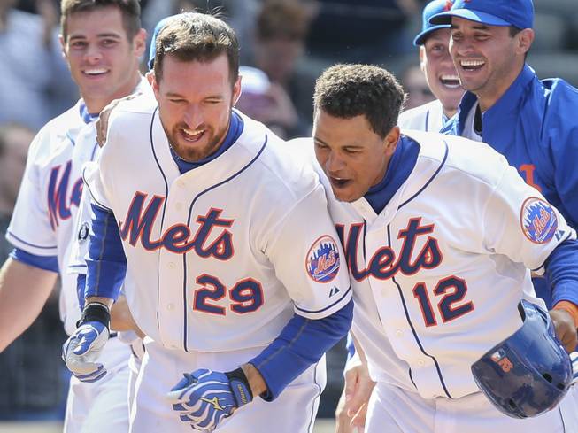 New York Mets first baseman Ike Davis (29) celebrates his walk-off grand slam in the ninth inning with center fielder Juan Lagares (12) after their game against the Cincinnati Reds at Citi Field on Saturday, April 5, 2014, in New York. The Mets won, 6-3. 